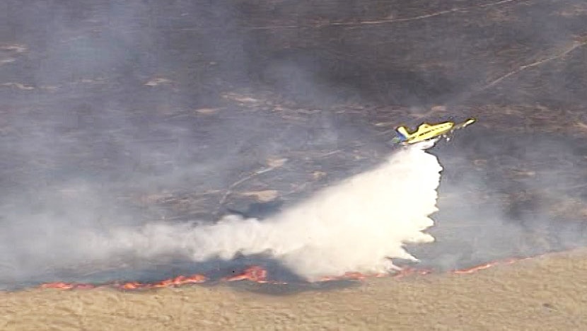 Plane waterbombs a bushfire at Frazerview, west of Kalbar, on Queensland's Scenic Rim