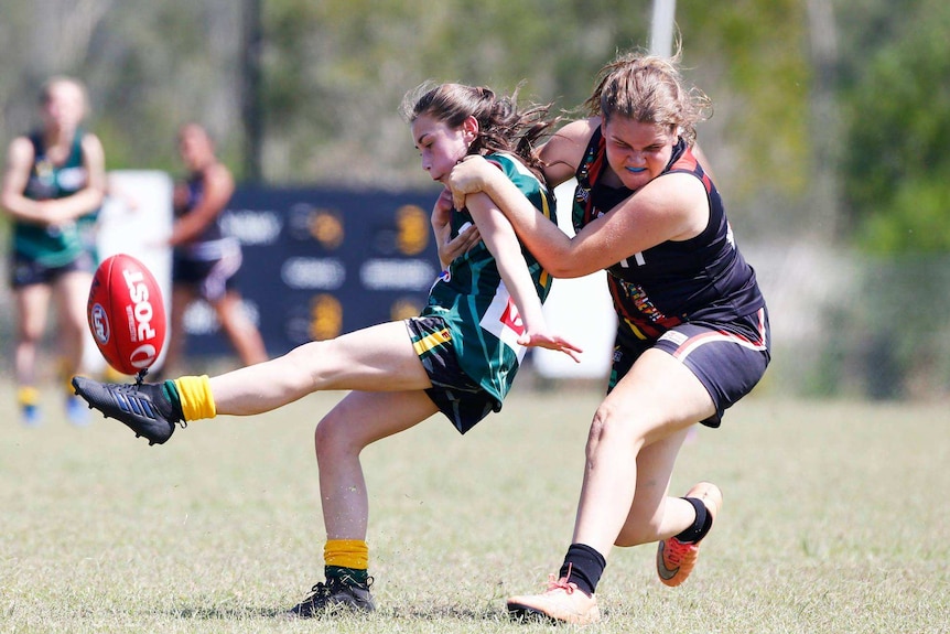 Two girls playing AFL football.