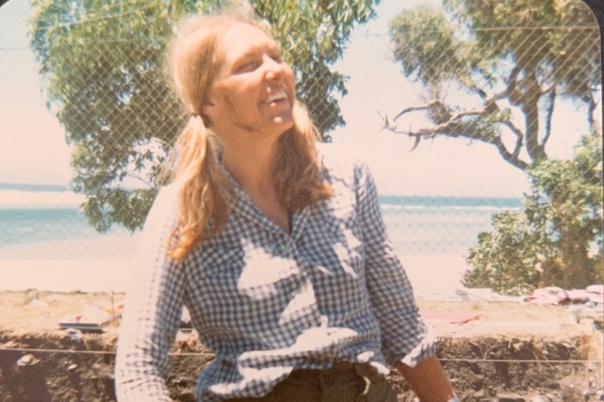 A young woman with pig tails has dirt on her face, she is holding an implement that looks like a trowl