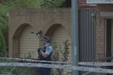 Officers and bystanders behind police tape