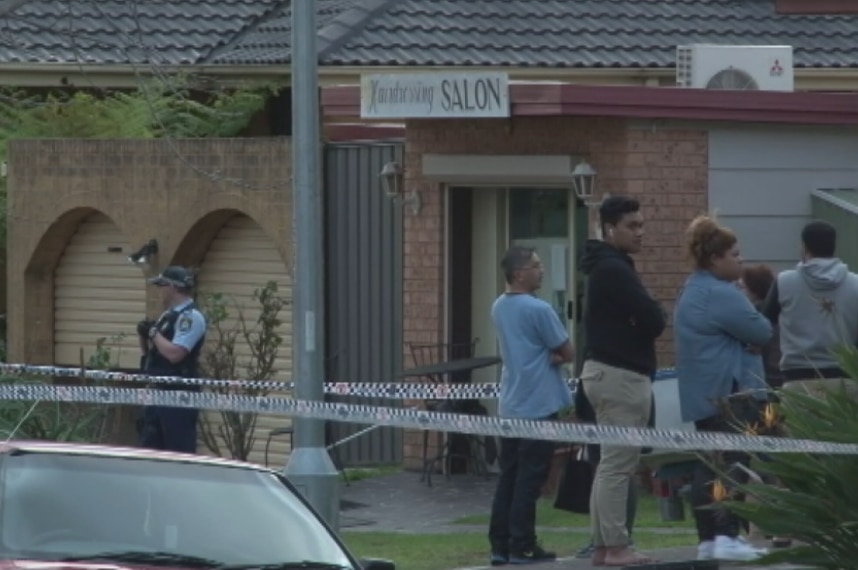 Officers and bystanders behind police tape