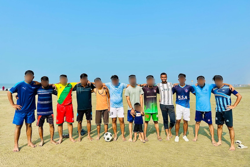 Samsul posing with a group of friends at the beach after playing football. 