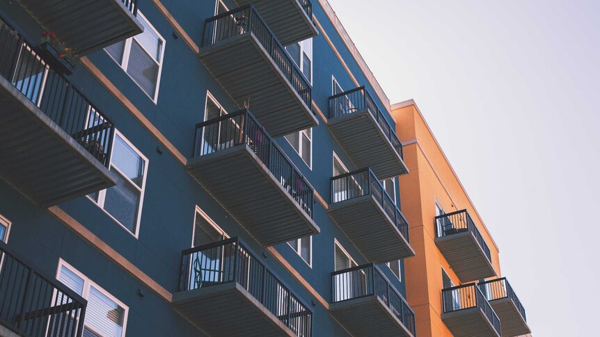 Blue and orange apartment buildings with black railings and windows