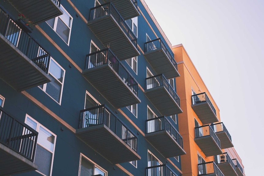 Blue and orange apartment buildings with black railings and windows