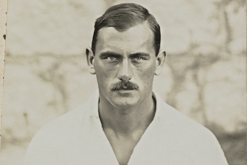 A photograph taken in 1914 of a man looking at the camera, with a serious expression