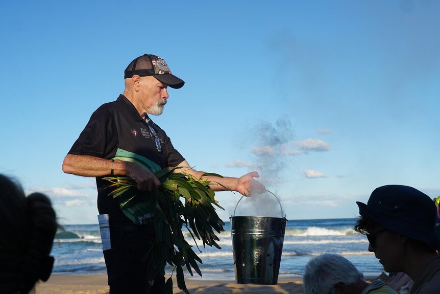 BJ Duncan doing smoking ceremony on the beach.