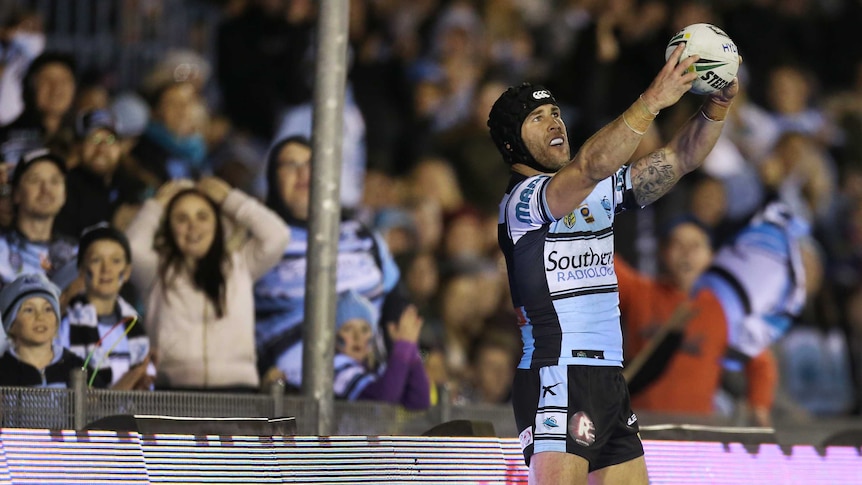Michael Ennis poses for a faux selfie after a try against the Warriors