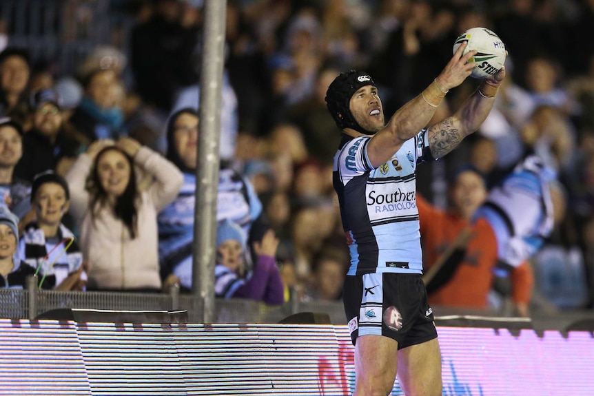 Michael Ennis poses for a faux selfie after a try against the Warriors