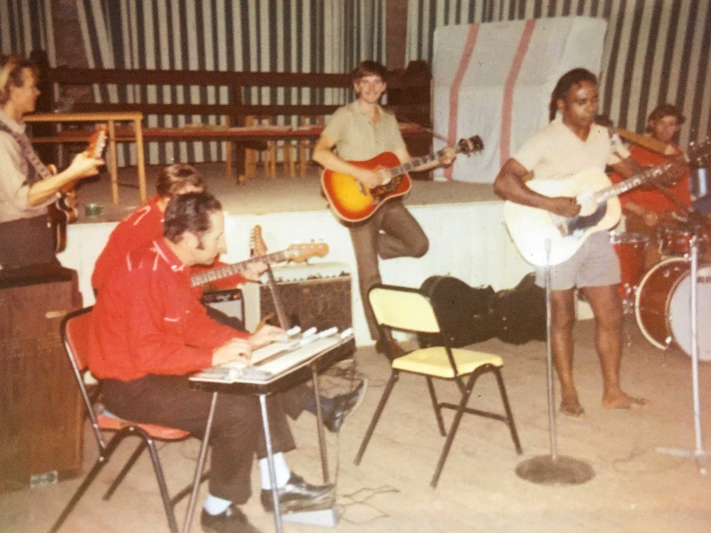 A band plays music in a shed.