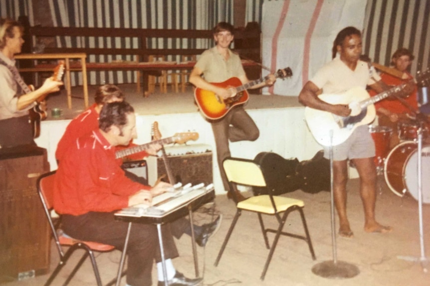 A band plays music in a shed.