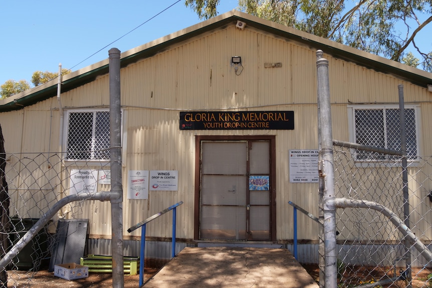 the drop-in centre entrance includin a fence and sign of 'Gloria King Memorial'