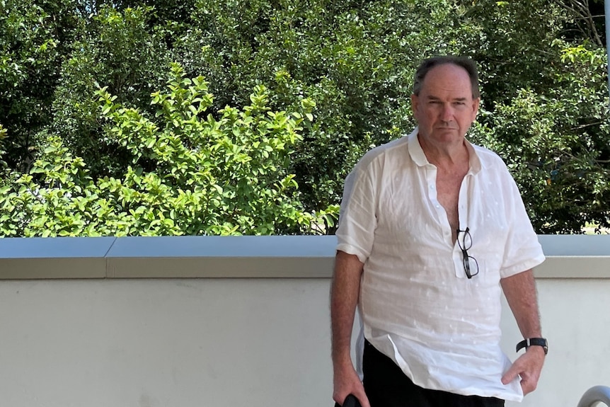 man standing outside a court house with a white shirt and black shorts