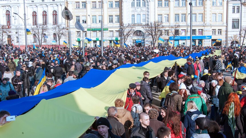 Pro-Ukrainian supporters carry a giant Ukrainian flag during an anti-war rally in Kharkiv