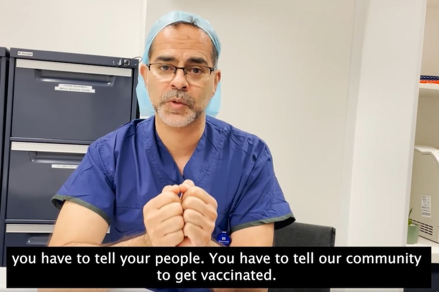 A surgeon in scrubs delivers a video message.