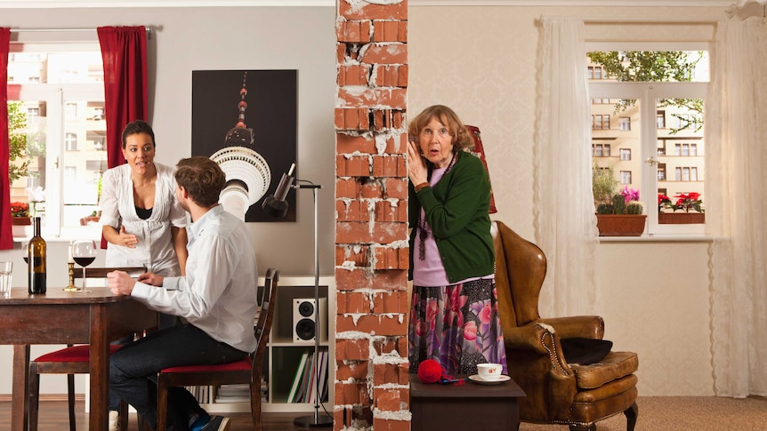two adjacent apartment rooms, one with a couple arguing and the other a lady looking shocked while listening at the wall