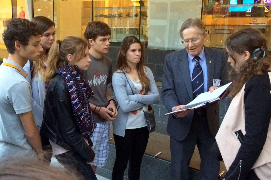 French teenagers meet with Ron Purssey, the son of a WWI digger outside the ABC building in Brisbane