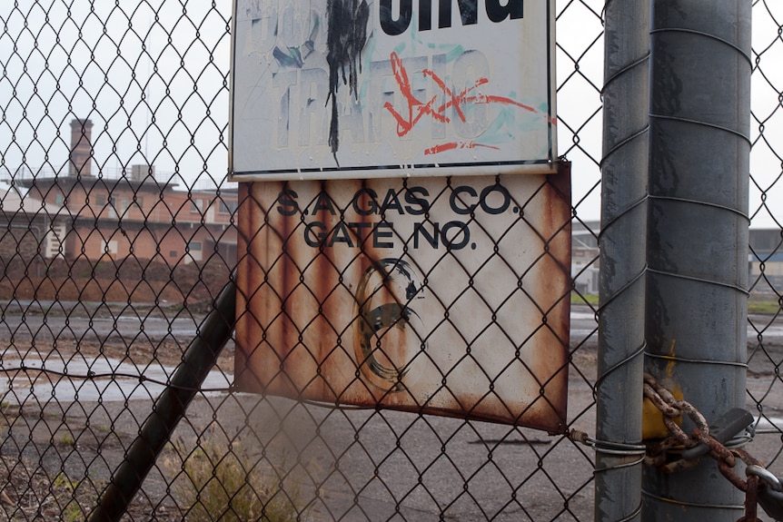 An old, rusted SA Gas Co sign on the southern border fence of the Brompton Gasworks site.