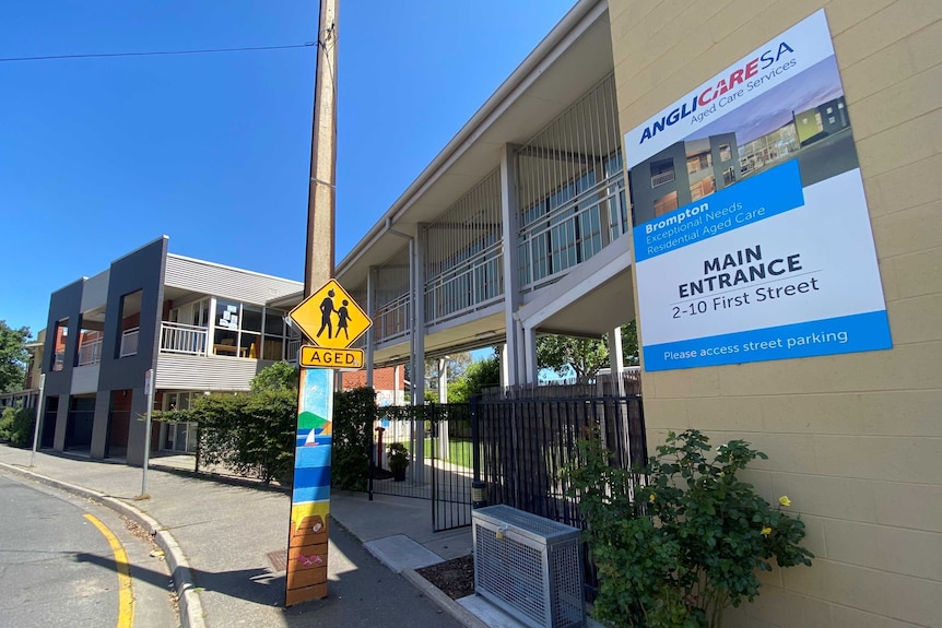 A two story building with a sign that says AnglicareSA Brompton