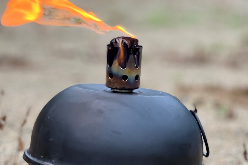 A black round lantern burns a red and orange flame.