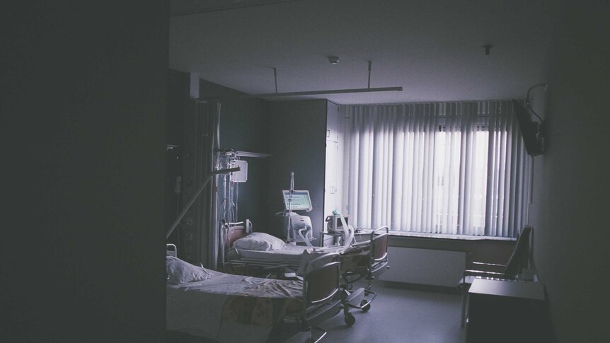 Beds in an empty hospital room in sepia light