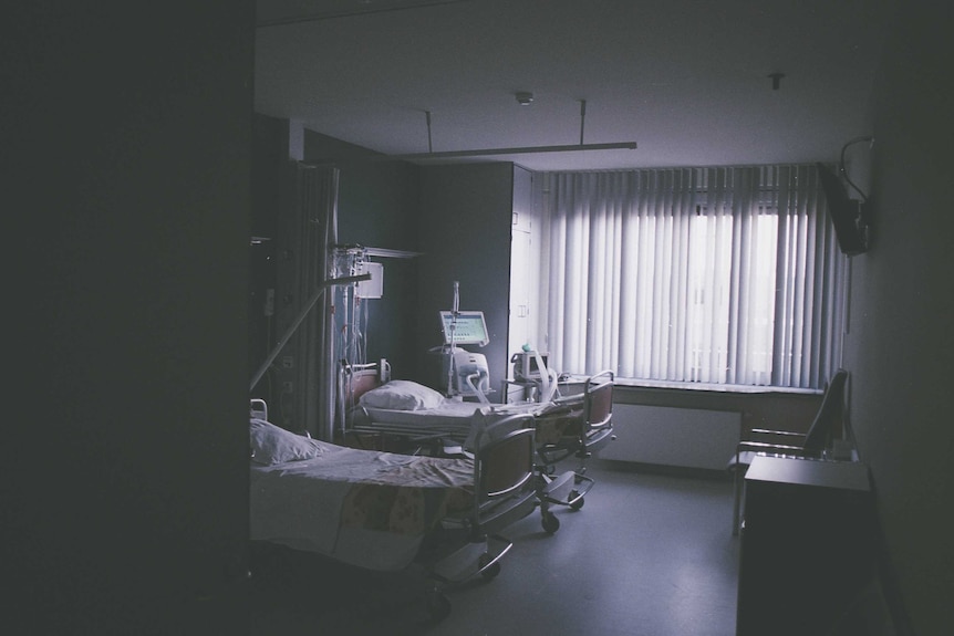 Beds in an empty hospital room in sepia light