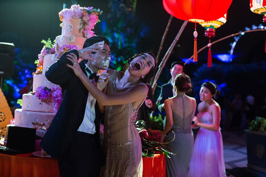 Colour still of Chris Pang and Sonoya Mizuno as newly weds at their wedding reception in 2018 film Crazy Rich Asians.