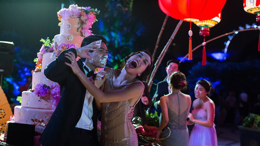 Colour still of Chris Pang and Sonoya Mizuno as newly weds at their wedding reception in 2018 film Crazy Rich Asians.