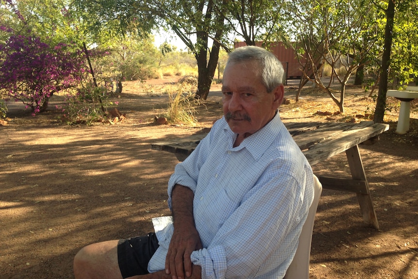 Elliot McAdam sits on a bench smiling.