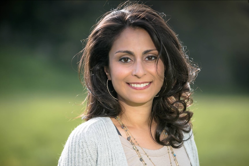 A woman with dark hair smiles at the camera 