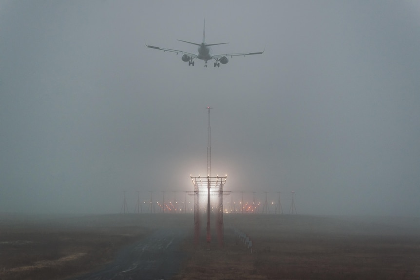 A passenger jet on final approach in heavy fog