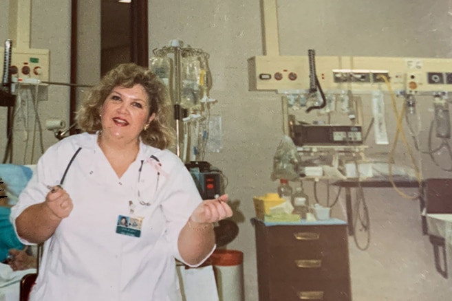 A nurse smiling in a hospital room.