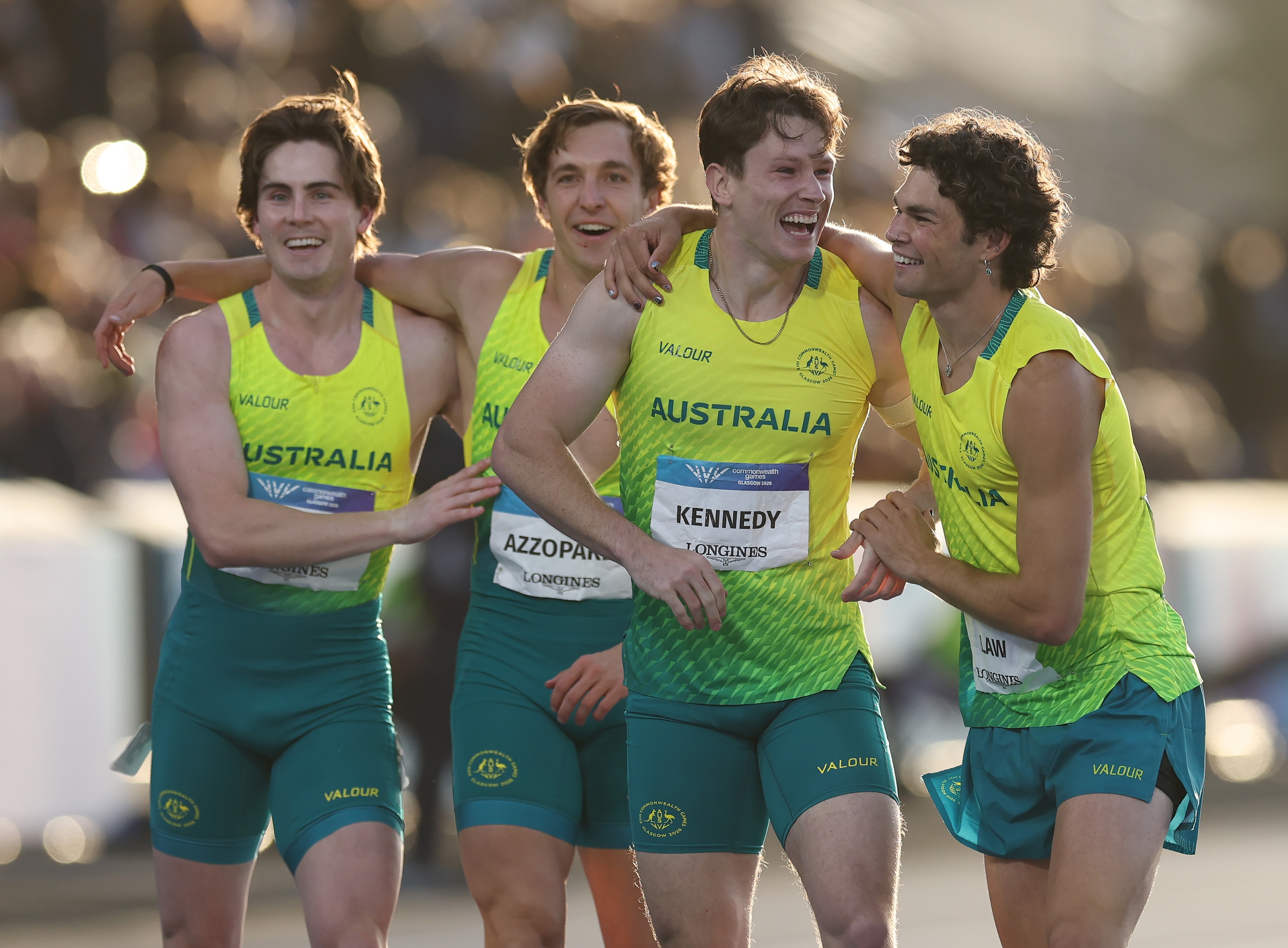 Three track athletes cenebrate after a race with arms around each other
