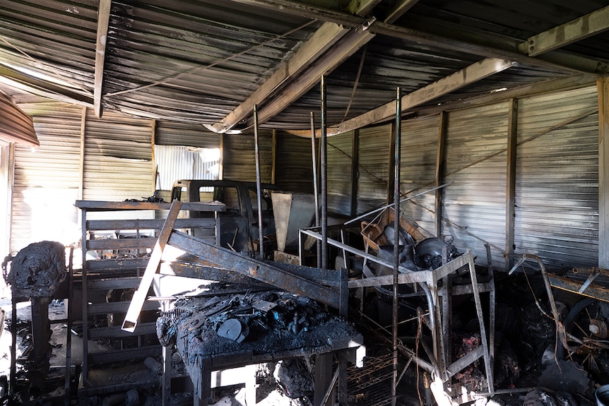 The inside of a burnt shed with the roof collapsing in