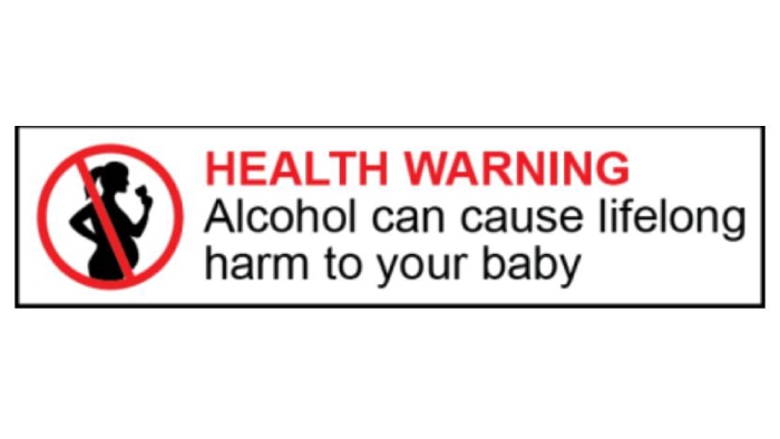 A label shows the silhouette of a pregnant woman drinking with the words HEALTH WARNING: Alcohol can cause lifelong harm to baby
