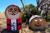 two hay bales that have been turned into santa and a reindeer