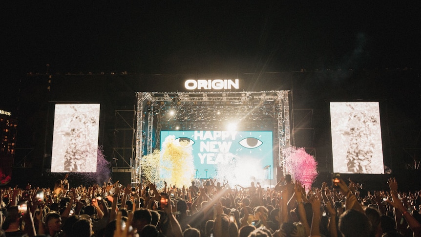 A wide shot of the 'Origin Fields' stage with 'Happy New Year' written on a screen.