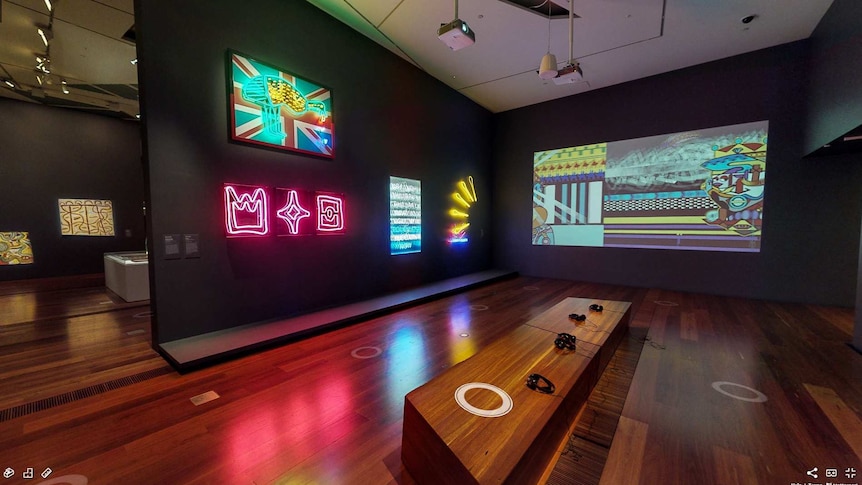 Gallery with black walls and art in bright neon and animation.