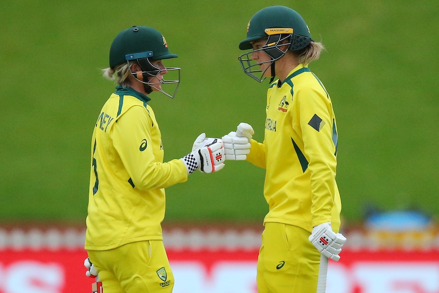 Two Australian batters touch gloves during their innings against Bangladesh at the Women's Cricket World Cup.