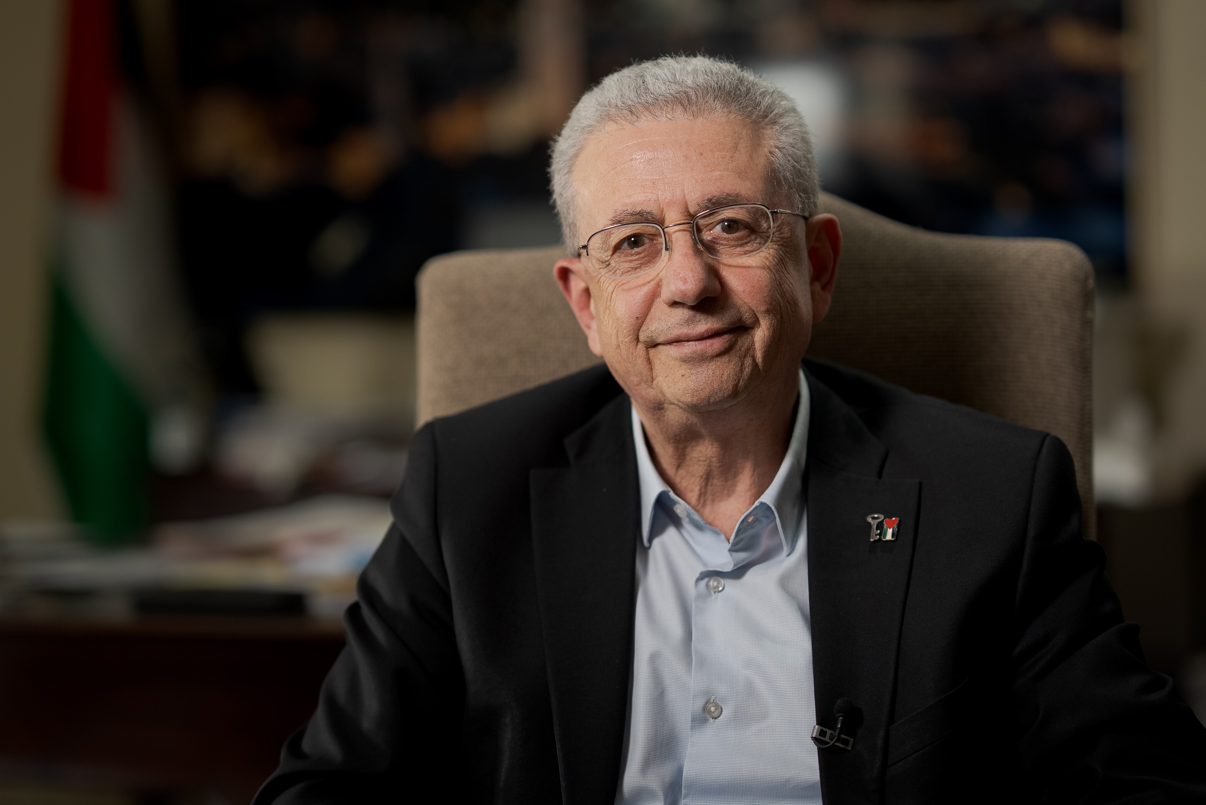 A man sitting in an office, smiling.