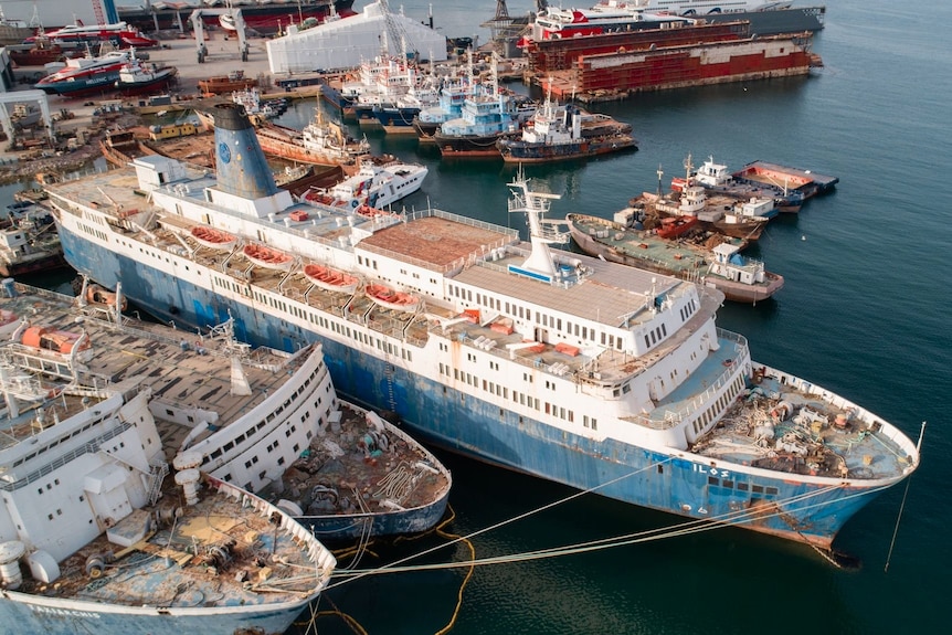 Aerial view of an old ferry in amongst other old ships.