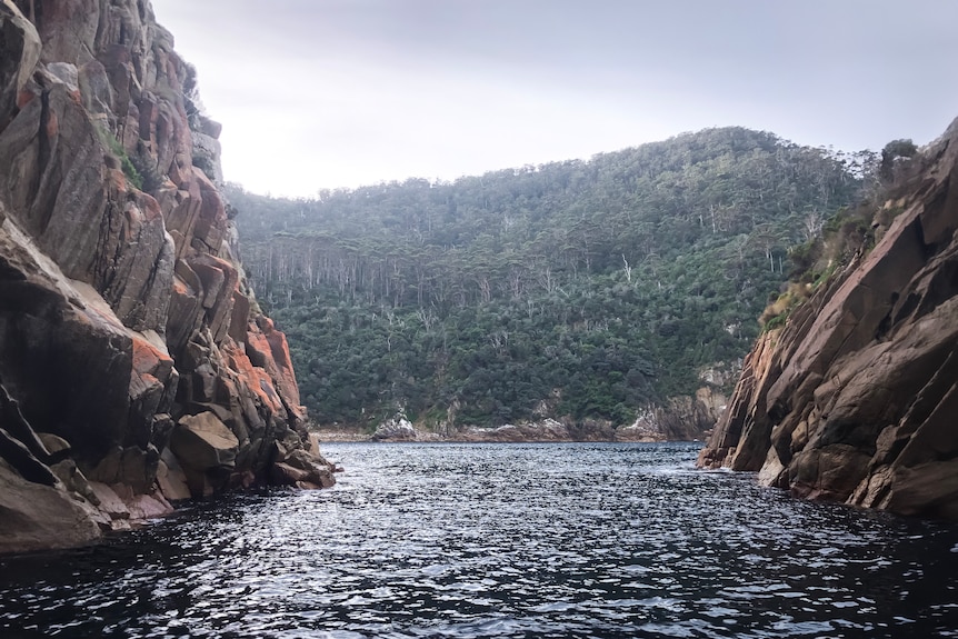 Stark cliffs tower over an isolated and chilly body of water.