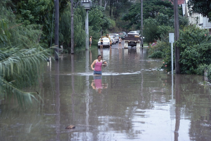 A man wades through flood waters
