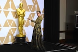 Frances McDormand poses next to an Oscar statue