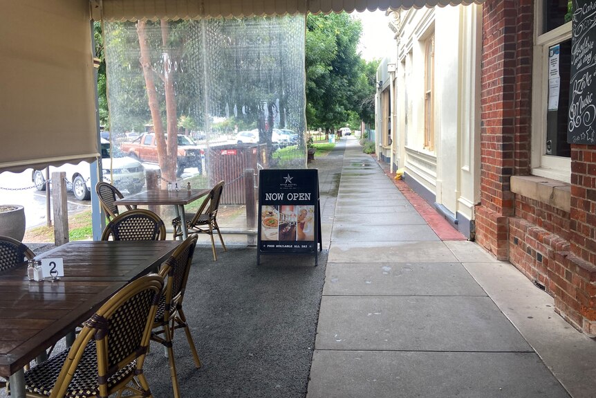 a photo of an Echuca footpath outside a pub, showing empty street and seats 