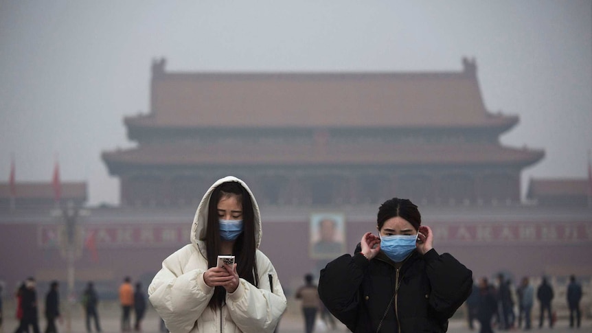 Women wear masks to protect against pollution as they visit Tiananmen Square, Beijing, China.