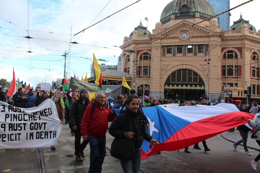 Protesters are seen walking in Melbourne in front of the iconic Flinder's street.