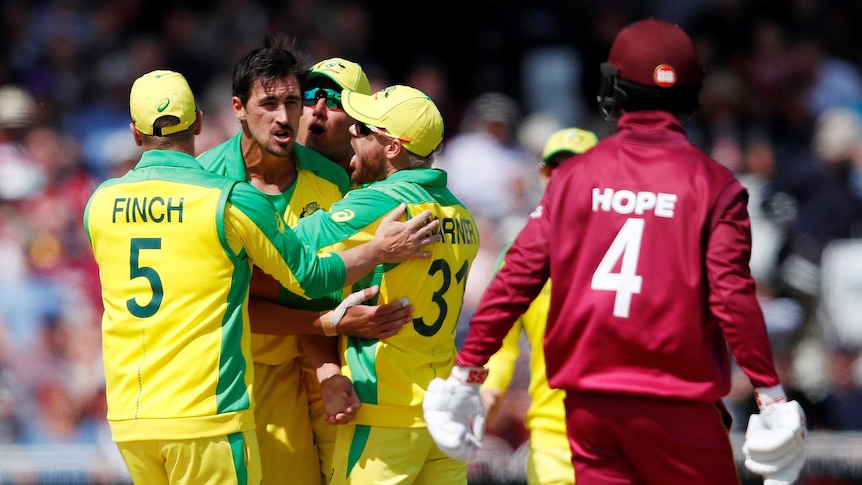 Mitchell Starc is embraced by teammates with Hope in the foreground.