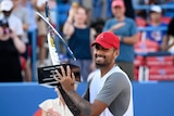 Nick Kyrgios poses and smiles with the Washington Open trophy
