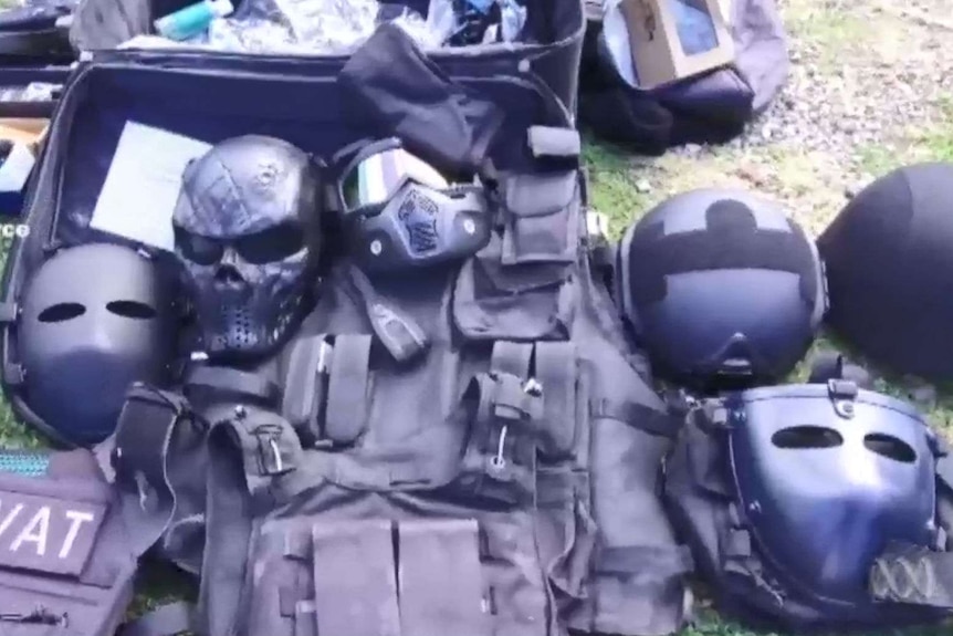 armoured vests and masks laid out on grass