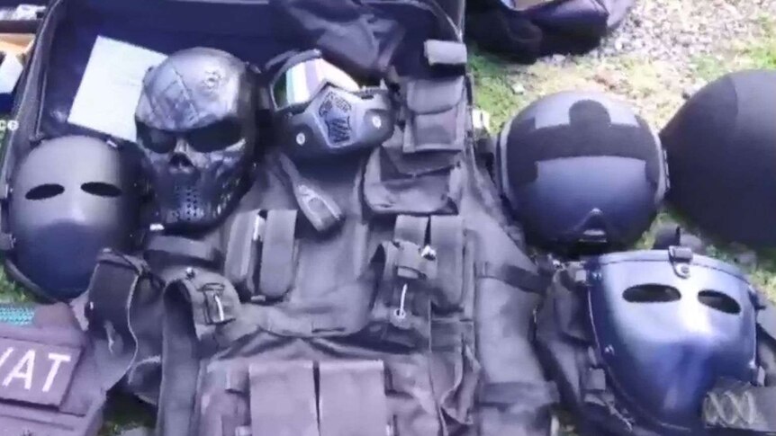armoured vests and masks laid out on grass